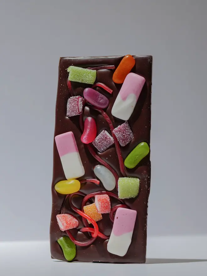 Rainbow sweet chocolate tablette standing on a white table. 