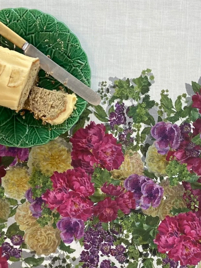 Isabel’s Roses. A tablecloth patterned with vibrant pink and red roses and anemones.