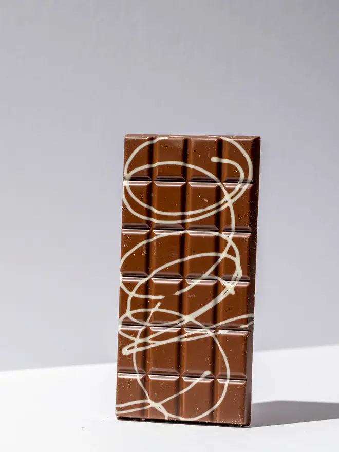 Popping candy chocolate tablette standing on a white table. 