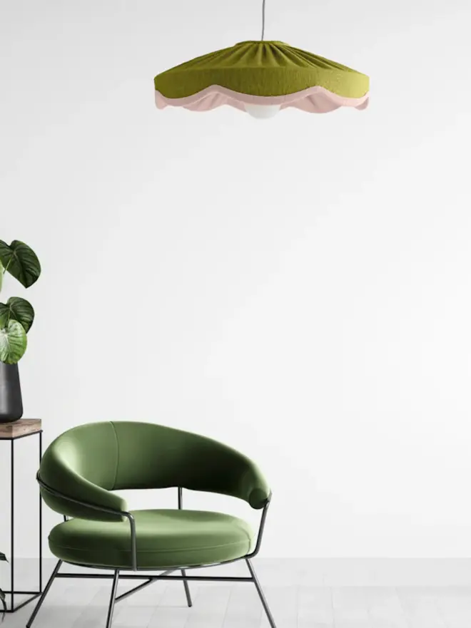 green and pink lampshade hanging above green chair
