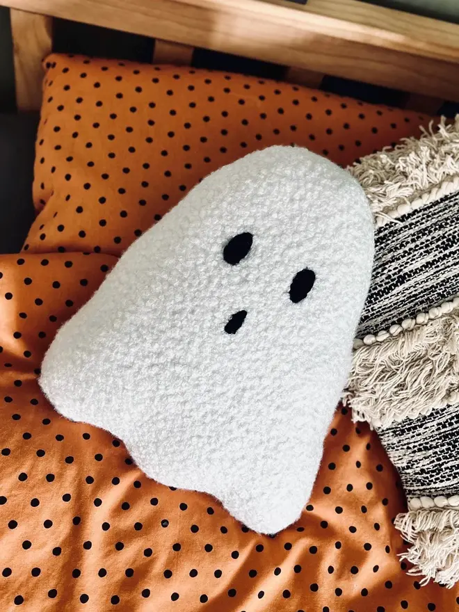 boucle ghost pillow. a white cushion in the shape of a ghost.