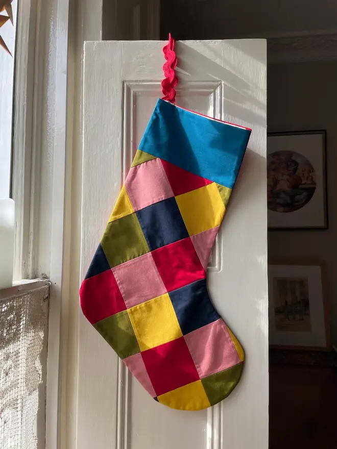 Harlequin Patchwork Stocking Kit, by a fire place. 
