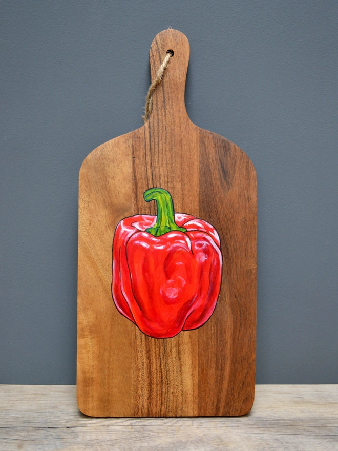 Wooden serving board with handpainted red pepper design