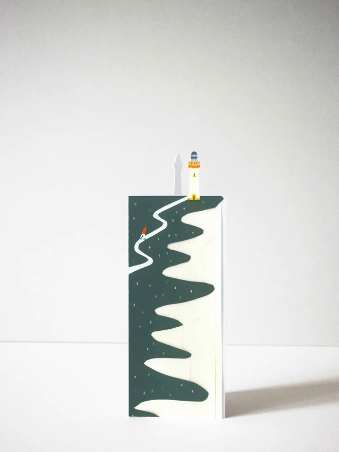 Cut out card of a cliff with a lighthouse