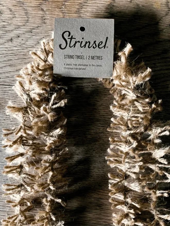 Natural Gold Strinsel with label AKA Jute string tinsel on an oak table