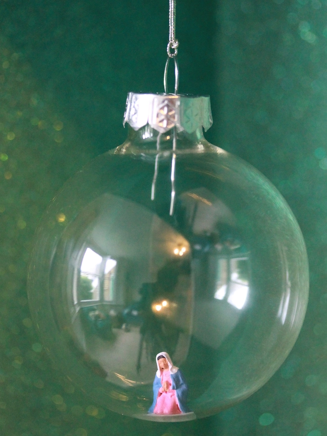 Miniature figure of Mary in a glass Christmas bauble (part of nativity scene)