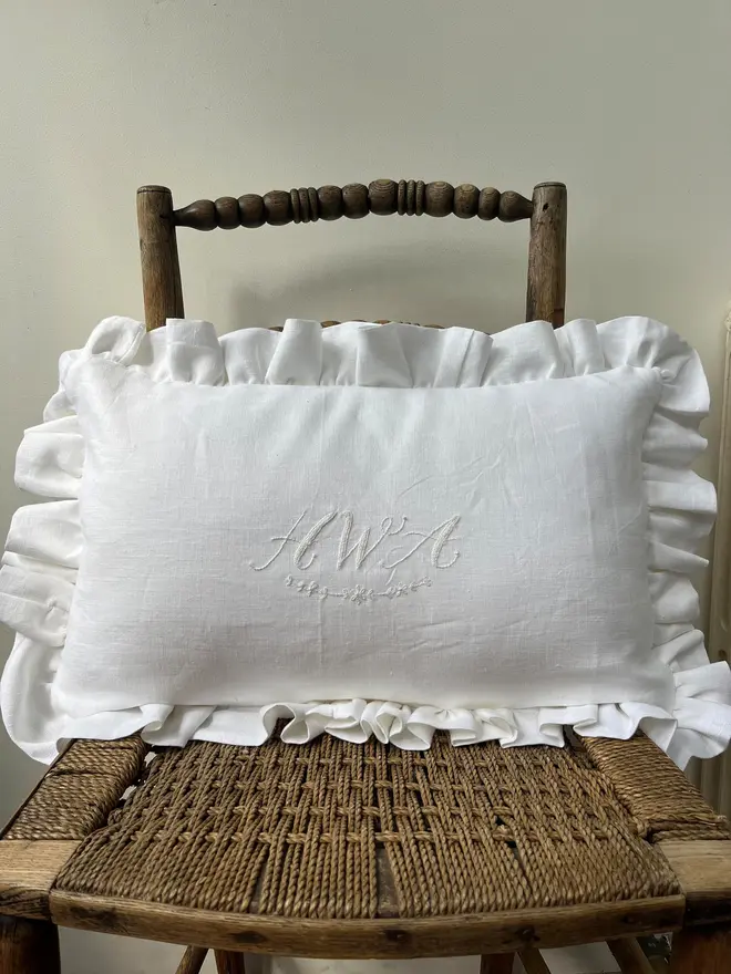 Personalised Handmade Embroidered Linen Cushion With Ruffle, white cushion on a chair with a personalised message. 
