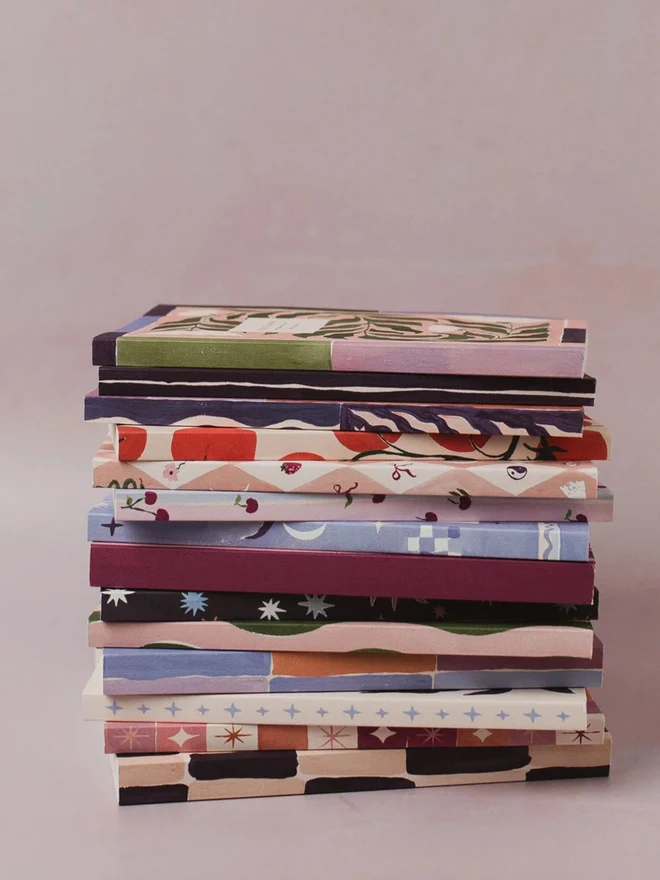 A stack of Sister Paper Co notebooks and planners