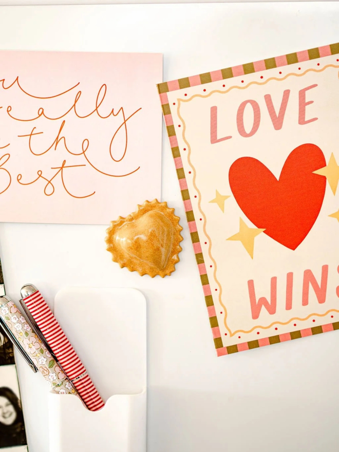 ceramic pasta magnet. a ceramic heart-shaped ravioli magnet on a fridge door.