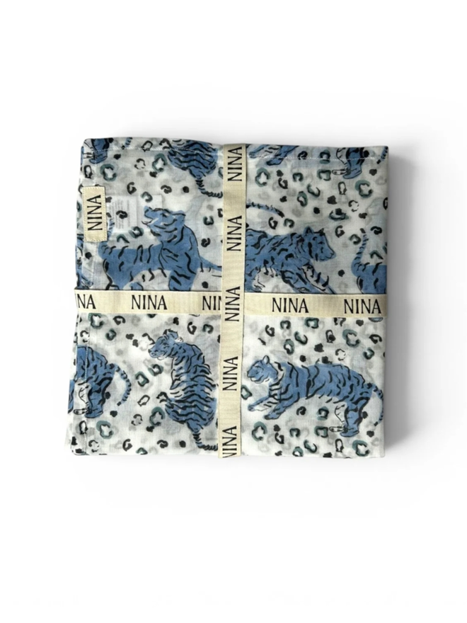 Whimsical Tigers Muslin. A folded blue and white muslin with a tiger pattern.