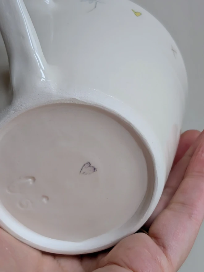 handmade ceramic cup for mum with flowers, daisy hearts and tiny honey bee in white earthenware with pink highlights