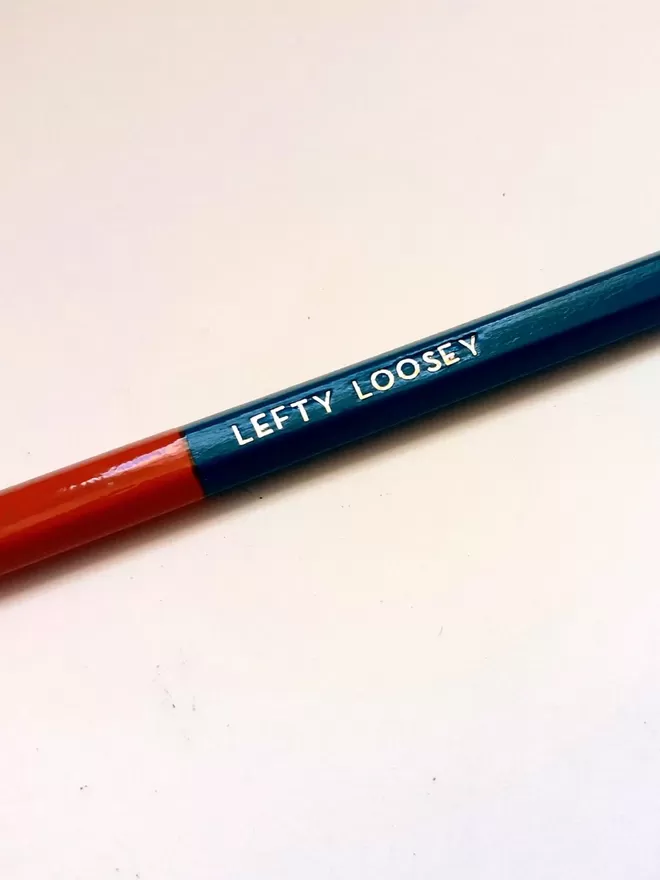Close up of one pencil with a red head and 'lefty loosey' text.