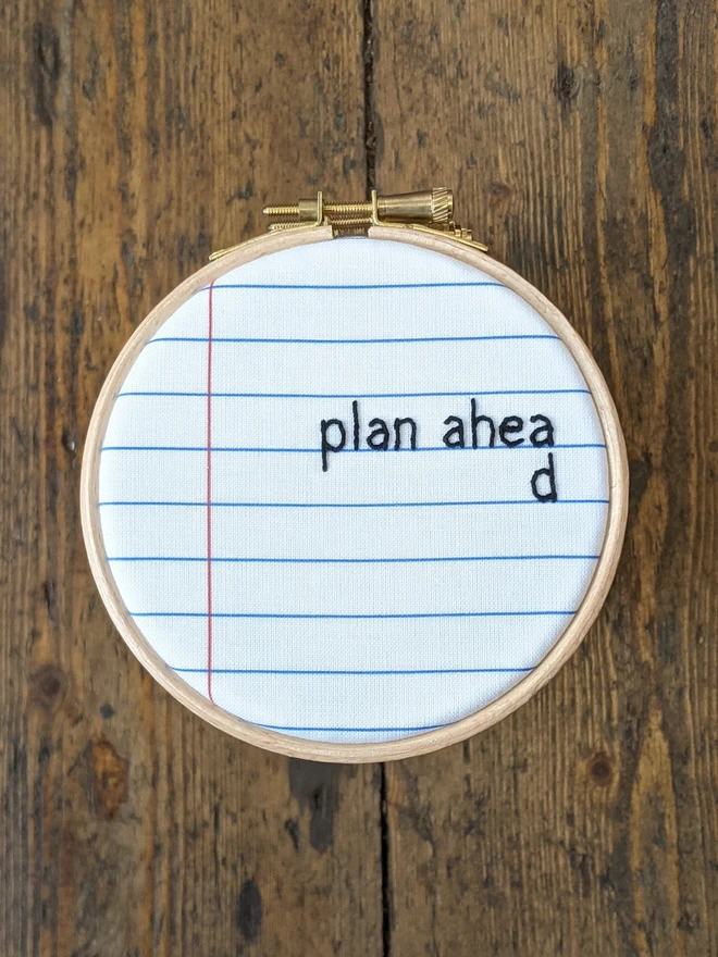 An embroidered hoop saying plan ahead, with the final 'd' on the line below becuase there is no room above.