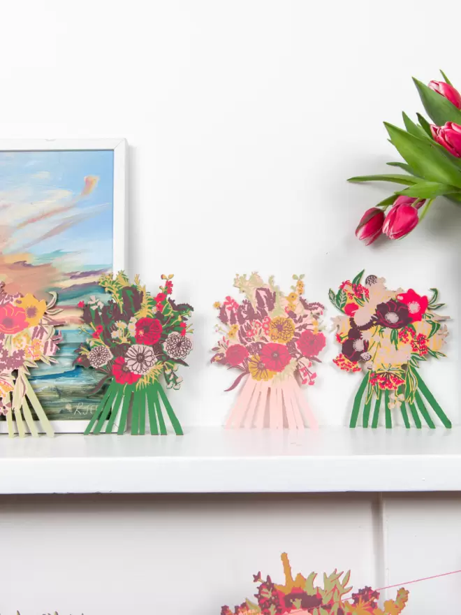 Full shot of image of all 4 flower cards aligned on a shelf  