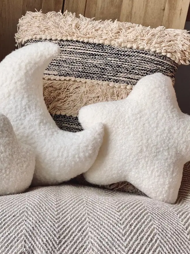 boucle moon star and cloud trio. star and moon shaped cushions on a sofa.