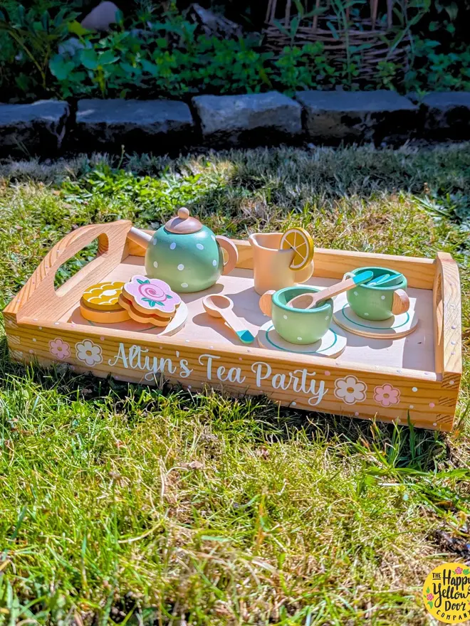 personalised wooden tea set. a personalised wooden tray and toy tea set on grass.