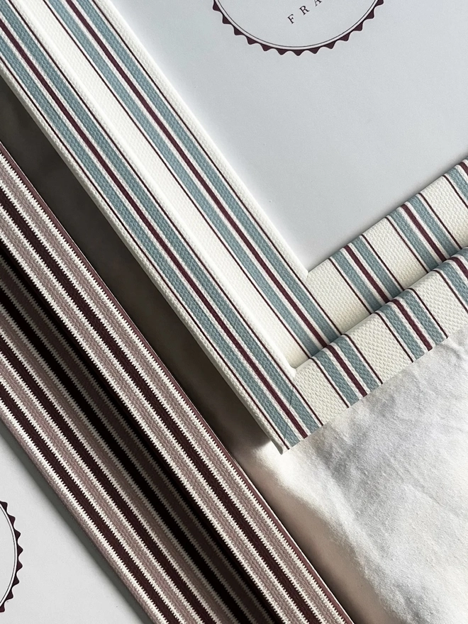 Sky & Scarlet Tailor Stripe Frame, a patterned colourful frame sitting on a plain white surface. It is joined by another frame. 