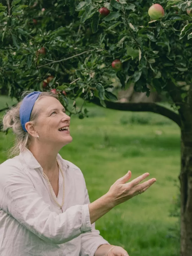 Vanessa Rose Ines Hairband in French Blue seen on a woman outside throwing apples.