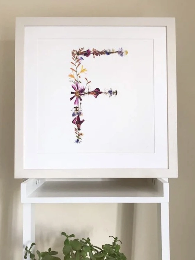 Pressed Wildflower Letter Print, a wildflower alphabet letter print sitting framed. 