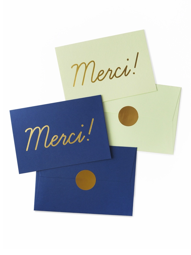 Set of 2 elegant gold foil Thank You cards featuring Merci type in gold on navy and mint paper with gold envelope seal sticker.