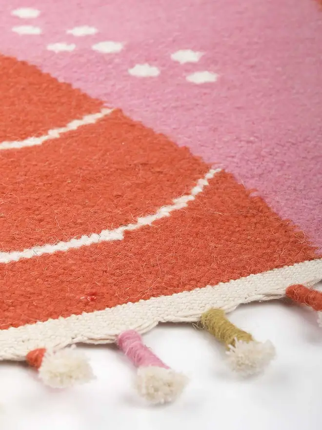 Landscape Flatweave Rug, a colourful rug sitting on a plain white surface. 