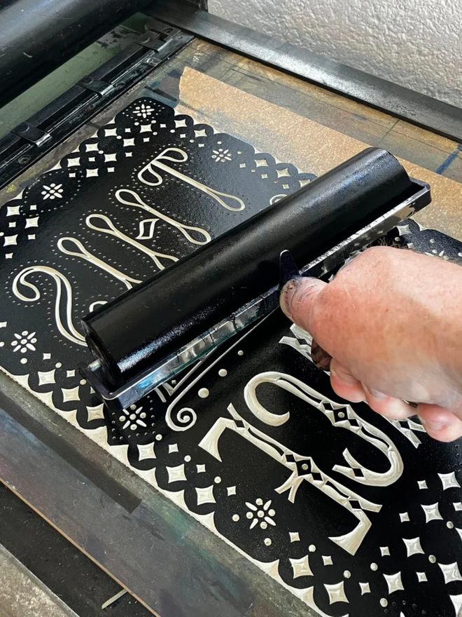 this is the place linocut. a linocut phrase printed with black paint.