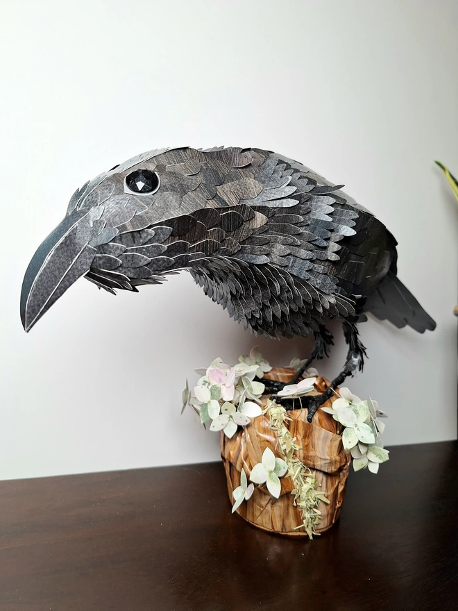 Rav3n sculpture perched on a tree stump