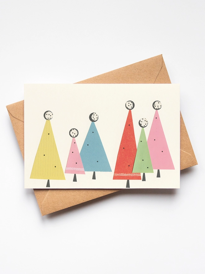A Christmas card featuring a forest of abstract trees in pastel colours.
