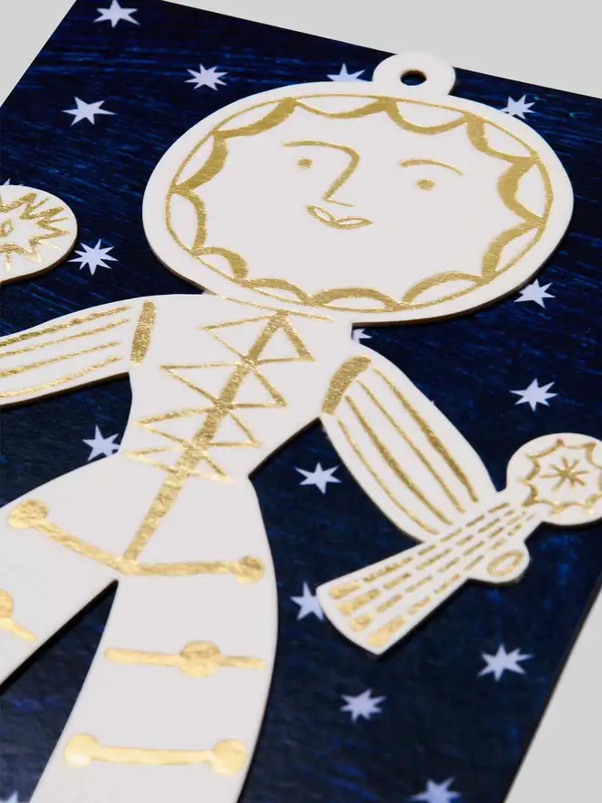 Decorative Sun Folk ornament with gold detailing on a blue background with stars