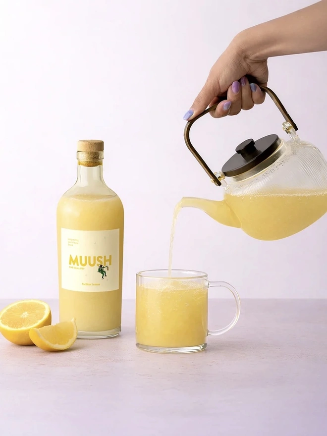 Sicilian Lemon Elixir, a drink being poured accompanied by a bottle of soft drink and some lemons. 