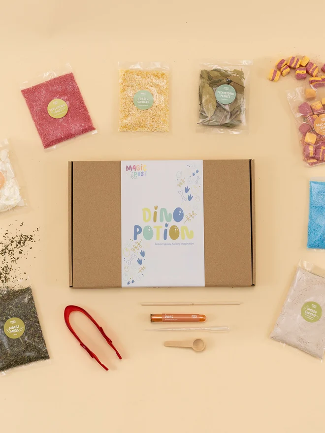 dino sensory potion kit. nine bags of assorted sensory materials placed into a cardboard box.