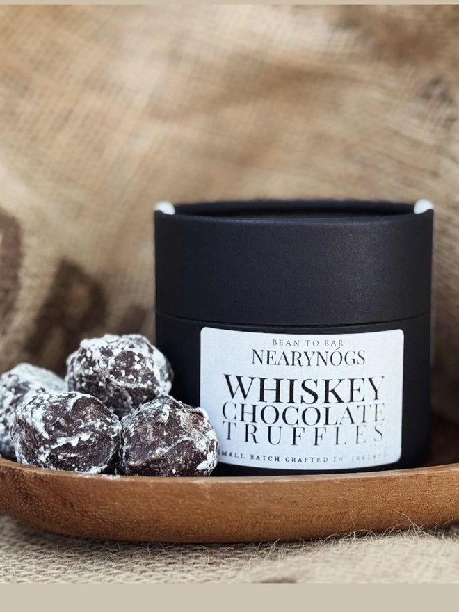 Chocolate Truffles, a tub of chocolates sitting on a sack backdrop accompanied by chocolate truffles. 