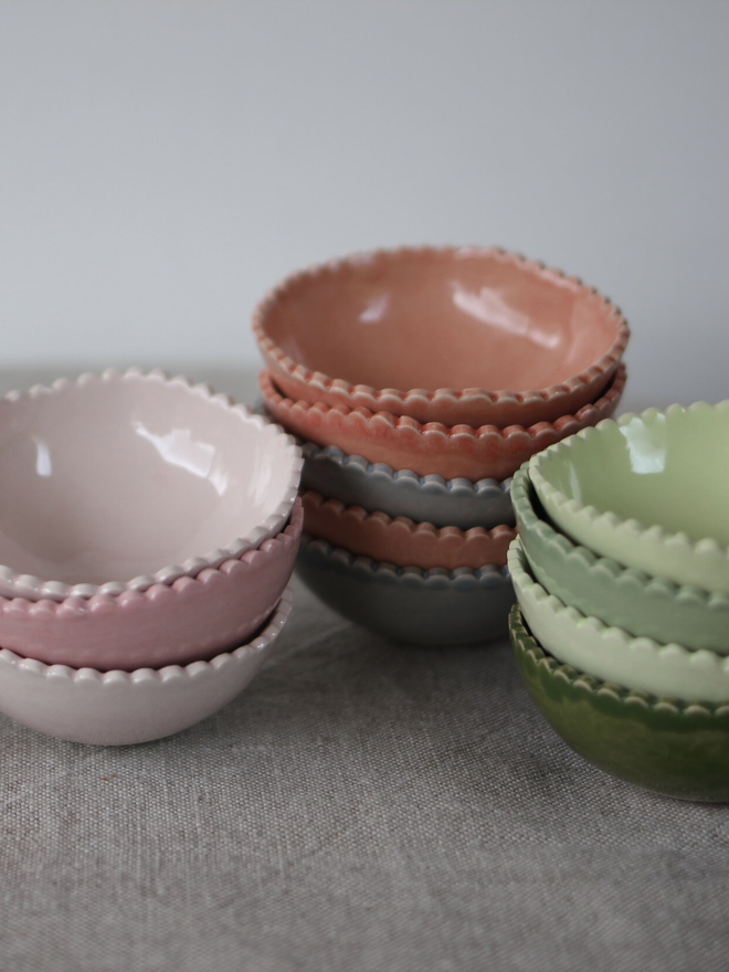three stacks of small pinch pots in pastel colours