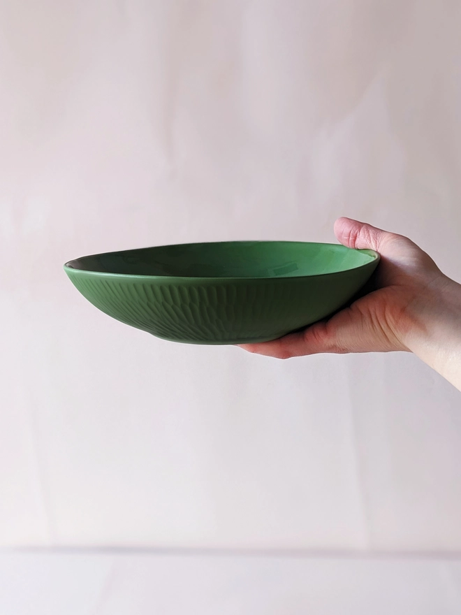 Porcelain Pasta Bowl in Dark Angelica Green with Hand Carved Scalloped Details Held in Hand