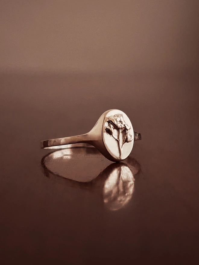 Sterling Silver Signet Ring with a real forget me not casting representing memories in the language of flowers on a dark background