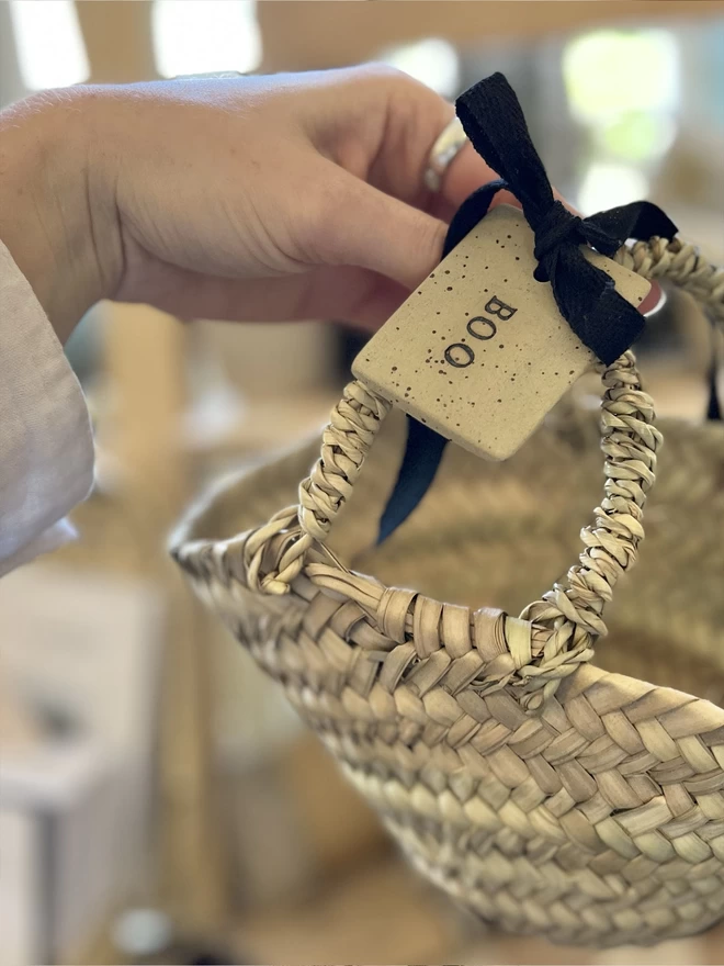 Ceramic 'boo' tag tied on a mini wicker basket