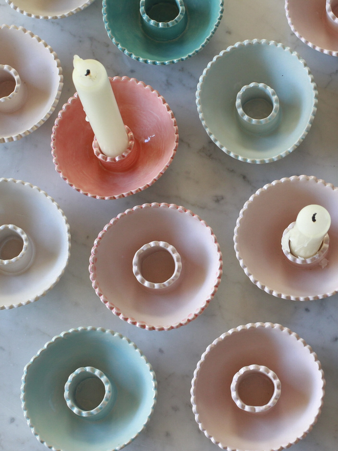 a top view of pastel colour low candlestick holders with scallop edge