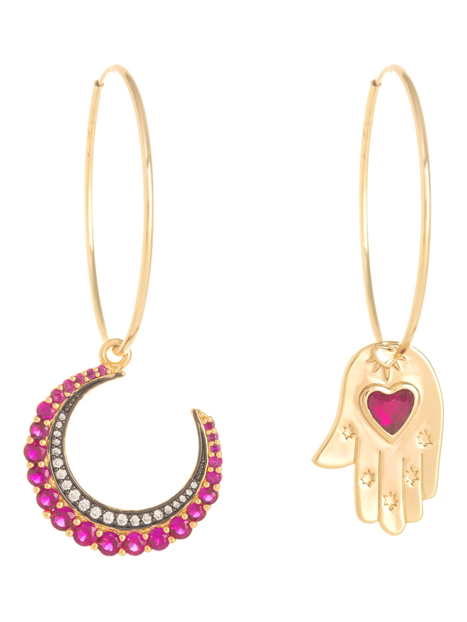Large gold hoop earrings with a pink crescent moon and a gold hand of hamsa charm hanging from them. On a white background.