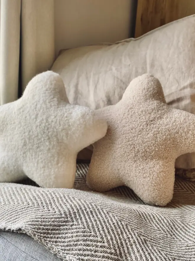 boucle star pillow. two star shaped pillow cushions on a sofa.