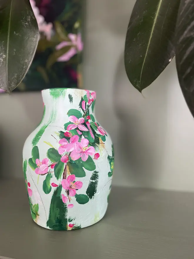 hand painted terracotta floral dried flowers vase pale green background with pink and white apple blossom flowers.