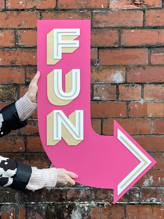 wooden arrow word sign in pink with the word FUN