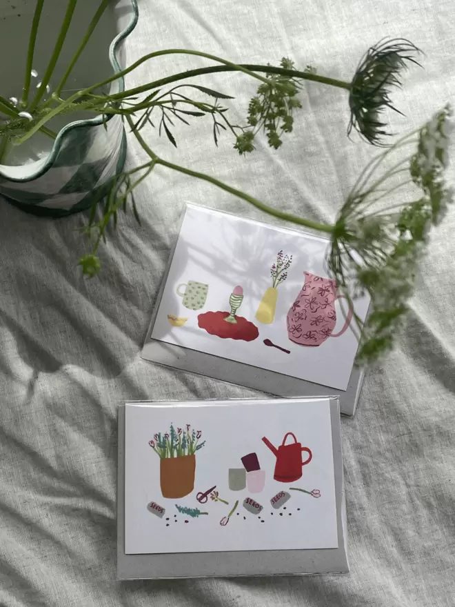 greetings card with jug, mug and a breakfast set up accompanied by a gardening card.