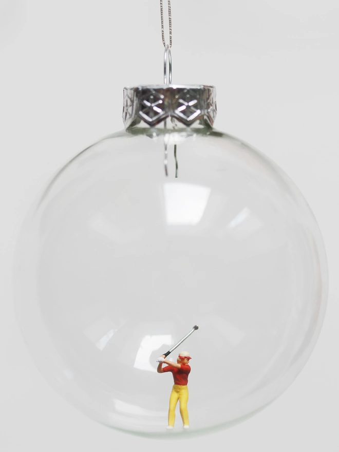 Miniature figure of a female golfer in a glass Christmas bauble 