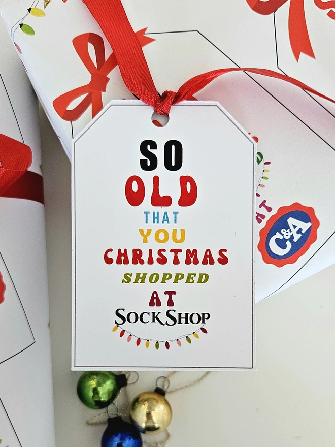 A gift tag on the present thats says so old that you Christmas shopped at Sock Shop to match the paper.