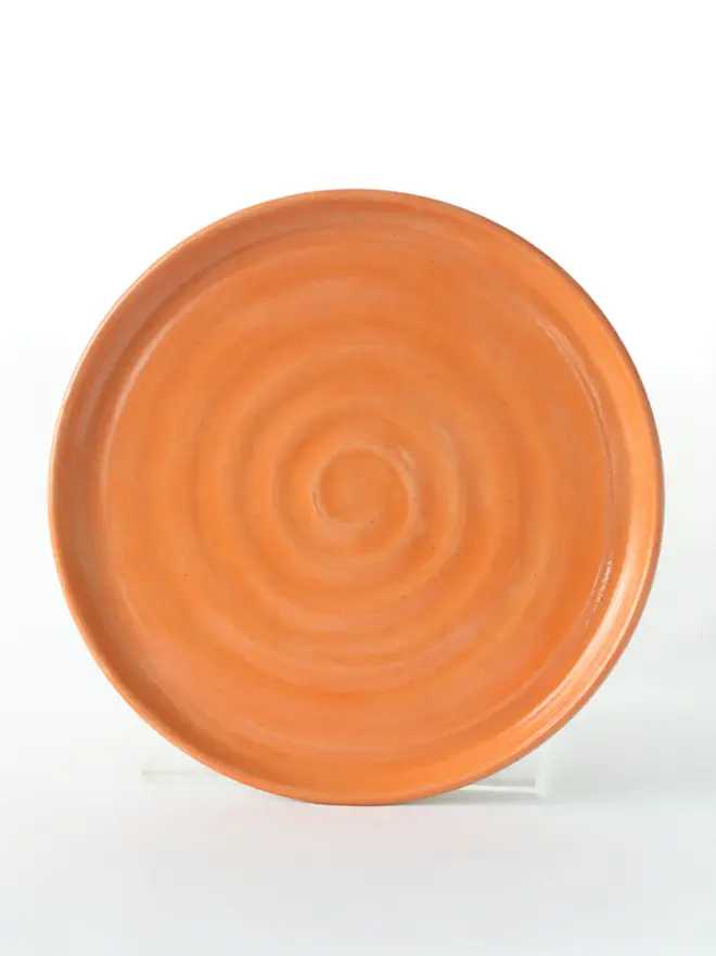 orange ceramic cake plate with textured swirl design