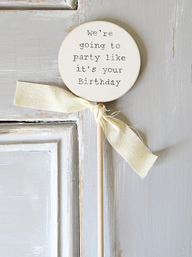 wooden circle shaped cake topper with hand painted message and custom ribbon