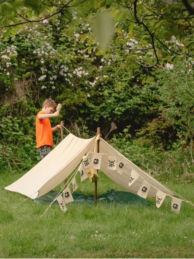 Children in a pirate den held up by wooden den poles