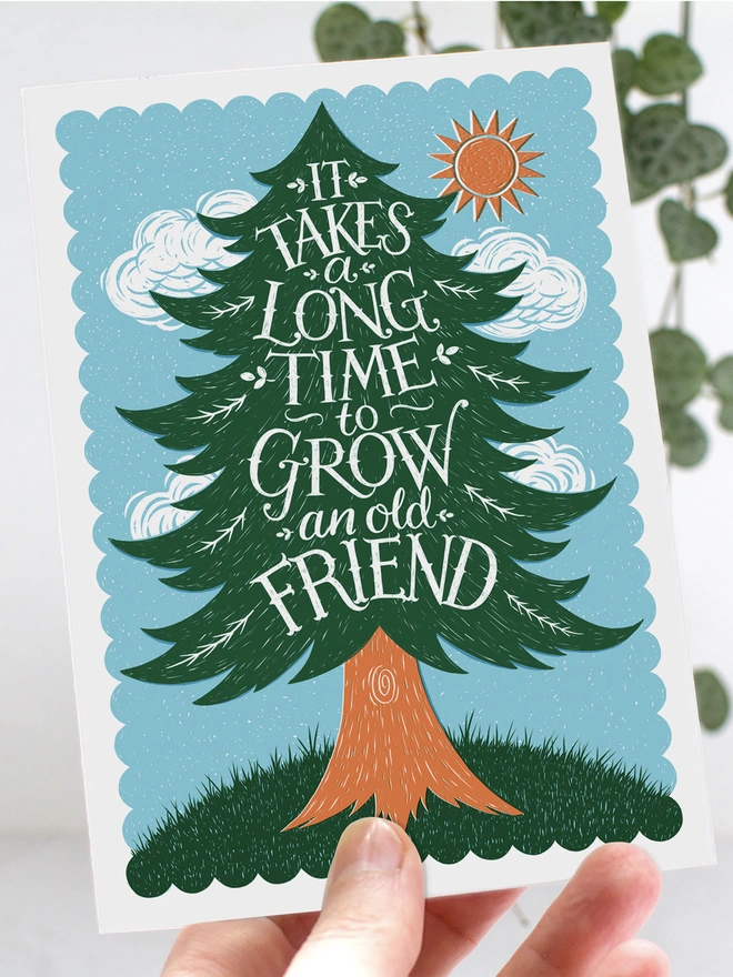 hand holding old friend pine tree card