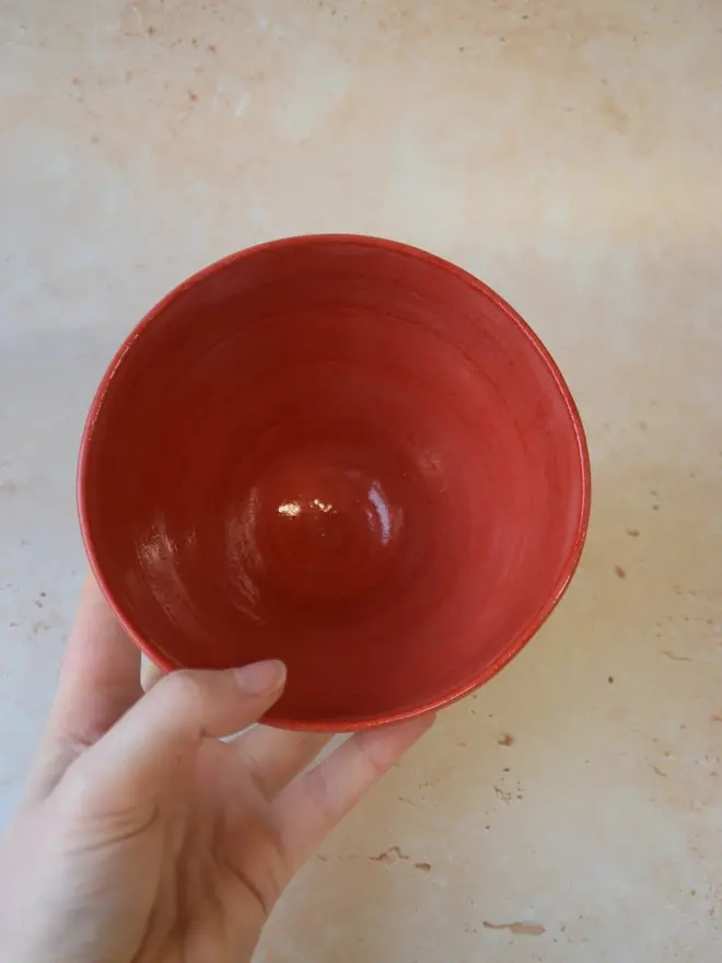 Handmade ceramic bowl — top view showing red glazed interior