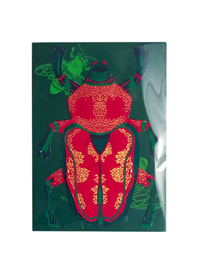 Full shot of image of red and gold beetle with matching envelope